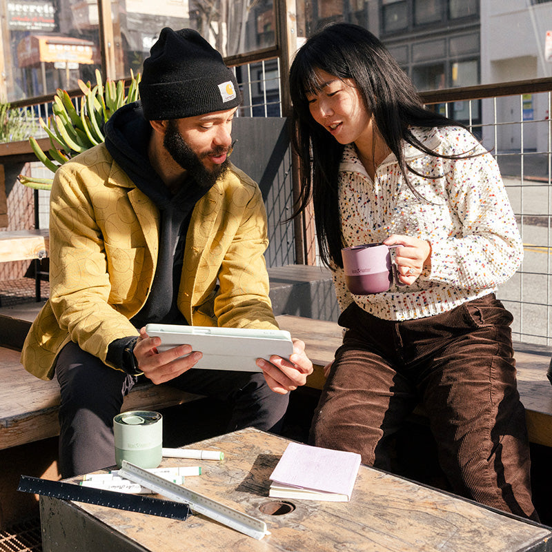 12oz-rise-mug-d7 12oz_rise_coffee_mug_dusty_orchid_couple_city_patio_square.jpg